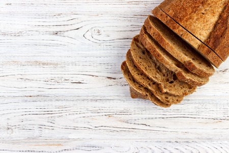 Slices of white bread on a wooden tablecloth, top view.の写真素材
