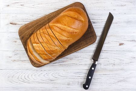 A slice of bread with knife on a chopping board.