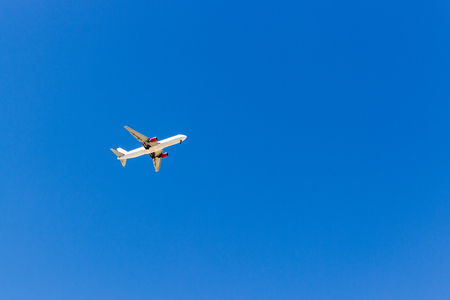A plane flying in the blue sky without white clouds.