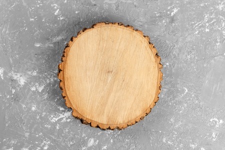 Tree stump round cut with annual rings on cement background. top view with copy space.