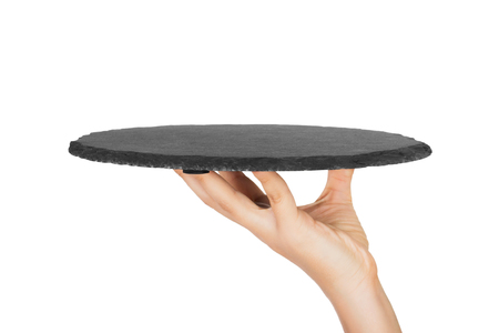 empty black slate round stone in the hand. perspective view Template for your design. isolated on white background.の写真素材