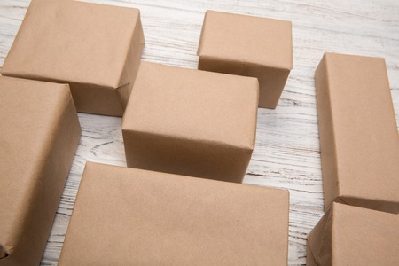 Brown mail package parcel blank for you design. Cardboard box on a wooden background.の写真素材
