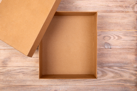 Opened cardboard box on a wooden table. top view.