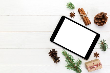 Digital tablet mock up with rustic Christmas wooden background decorations for app presentation. top...