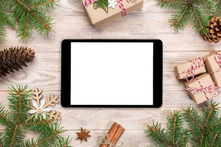 Digital tablet mock up with rustic Christmas wood background decorations for app presentation. top view with copy space.の写真素材