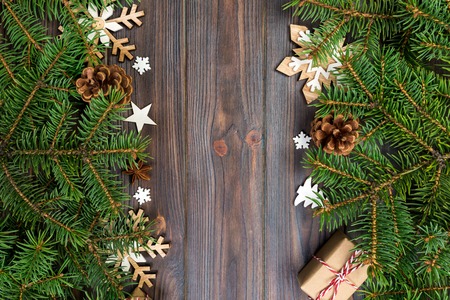 Christmas background with fir tree and gift box on wooden table. Top view with copy space for your...