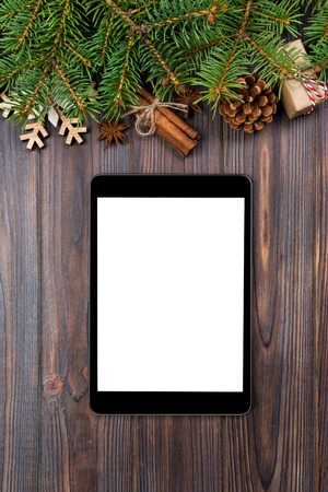 Digital tablet mock up with rustic Christmas wood background decorations for app presentation. top view with copy space.の写真素材