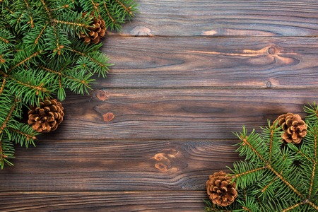 Christmas gray wooden background with fir tree frame and cones copy space. top view empty space for your design.の写真素材