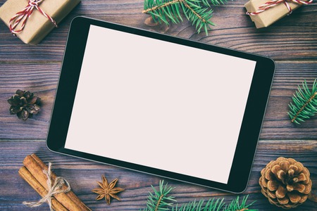 Digital tablet mock up with rustic Christmas wooden background decorations for app presentation. top view vintage, toned with copy space.の写真素材