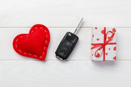 Valentine or other holiday handmade present in paper with red hearts, car keys and gifts box in...