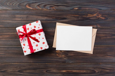 Envelope Mail with Red Heart and gift box over Dark Wooden Background. Valentine Day Card, Love or Wedding Greeting Concept.の写真素材