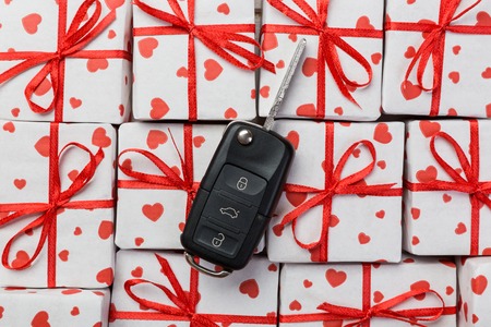 Valentine or other holiday handmade present in paper with red hearts, car keys and gifts box in holiday wrapper. box gift on white wooden table top view with copy space, empty space for design.の写真素材