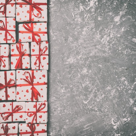 top view of various gift boxes. wrapped valentine or other holiday handmade present in paper with red ribbon and heart. Toned Present box, decoration of gift on wooden table.の写真素材