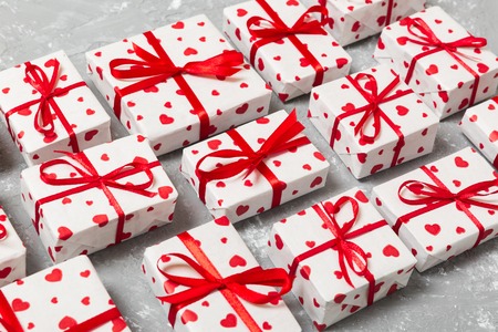 many gift boxes with red ribbon and heart. valentine or other holidays concept. top view toned on wooden background.の写真素材
