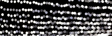 Abstract bokeh of white city lights on black background. defocused and blurred many round light.