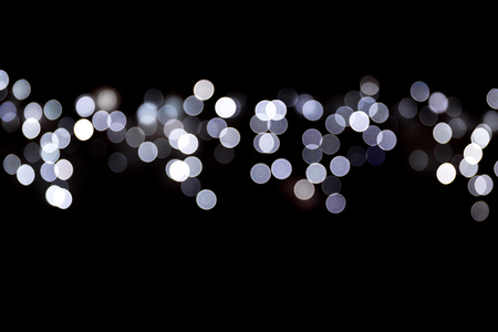 Abstract bokeh of white city lights on black background. defocused and blurred many round light.