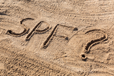 Sun protect factor concept. SPF word written on the beach with question mark.の写真素材