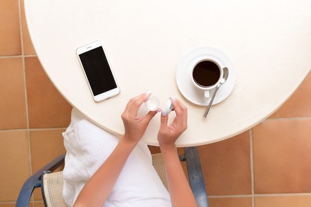woman uses a jar of cream for skin care product. Moisturizer in female hands. Beauty skincare and wellness morning concept.の写真素材