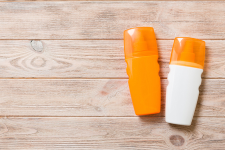 Two Sunscreen bottles on a bright wooden background, top view with copy space.の写真素材