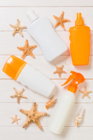 flat lay concept summer travel vacation. Sunscreen bottles with starfish on white wooden table with copy space.の写真素材