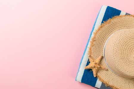 Straw hat, bluetowel and starfish On a pink background. top view summer holiday concept with copy space.の写真素材