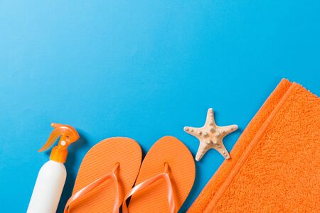 Top view of Beach flat lay accessories. sunscreen bottle with seashells, starfish, towel and...