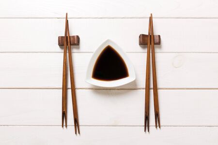 Soy sauce with chopsticks on white wooden table background.の写真素材
