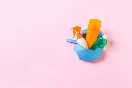 Top view of female cosmetics bag full of suncream spray, sunsreen, sunblock and body lotion and spf cream on pink background with copy space. Directly above. Bright summer concept.の写真素材