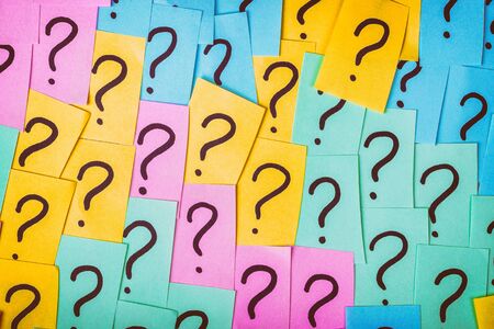 Question marks background. Colorful paper notes with question marks. Concept image. Closeup top view toned.の写真素材