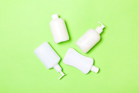 Set of White Cosmetic containers isolated on green background, top view with copy space. Group of plastic bodycare bottle containers with empty space for   design.の写真素材