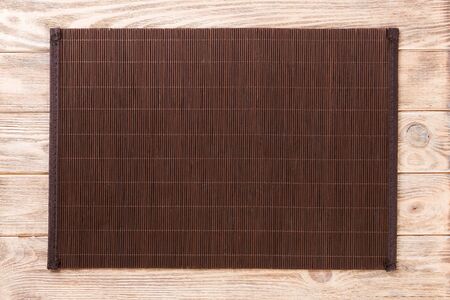 Empty Asian Food Background. Dank Bamboo mat on brown wooden background top view with copy space flat lay.の写真素材