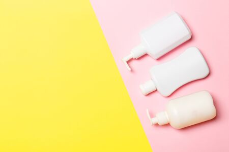 Set of White Cosmetic containers isolated on yellow background, top view with copy space. Group of...