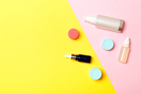 Group of plastic bodycare bottle Flat lay composition with cosmetic products on yellow and pink background empty space for you design. Set of White Cosmetic containers, top view with copy space.の写真素材