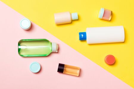 Top view of cosmetic containers, sprays, jars and bottles on pink background. Close-up view with empty space for your design.の写真素材