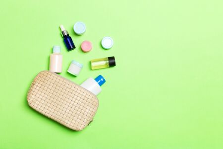 Top view of female cosmetics bag with dropped out cosmetic products on background. Bodycare concept with copy space.の写真素材