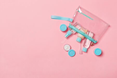 Top view of means for face care: bottles and jars of tonic, micellar cleansing water, cream, cotton pads on pinkbackground. Bodycare concept with empty cpace for your ideas.の写真素材