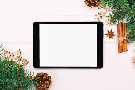 Digital tablet mock up with rustic Christmas wooden background decorations for app presentation. top view with copy space. Toned.の写真素材