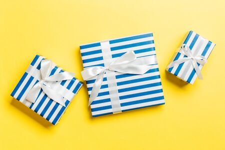 Gift box with White bow on yellow background, top view.の写真素材