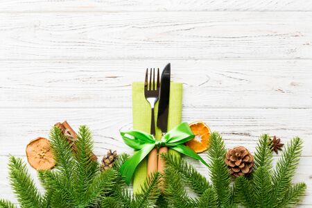 Top view of utensils on festive napkin on wooden background. Christmas decorations with dried fruits...