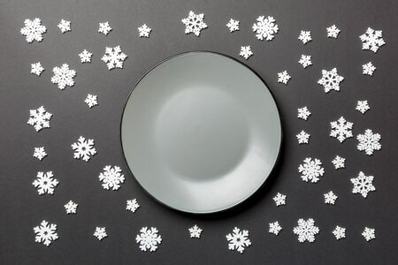 Top view of empty plate surrounded with snowflakes on colorful background. New Year dinner concept.の写真素材