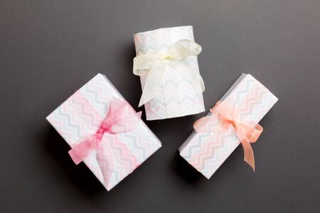 Gift box with Colored bow for Christmas or New Year day on black background, top view.