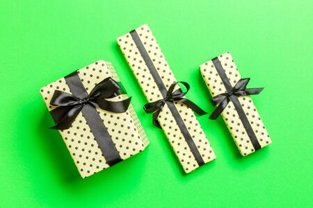 Gift box with Black bow for Christmas or New Year day on green background, top view.の写真素材
