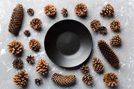 Top view of festive plate with pine cones on cement background. New Year dinner concept.の写真素材