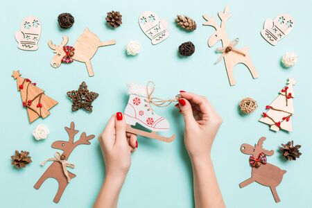 Top view of skates in female hands on blue background. Christmas decorations. New Year holiday concept.の写真素材