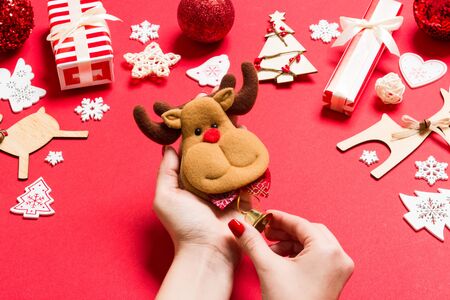 Top view of in female hands on red background. Christmas decorations. New Year holiday concept.の写真素材