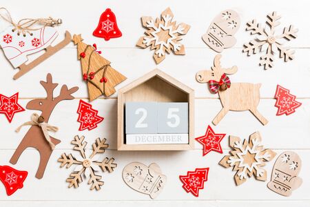 Top view of calendar on Christmas wooden background. The twenty fifth of December. New Year toys and...