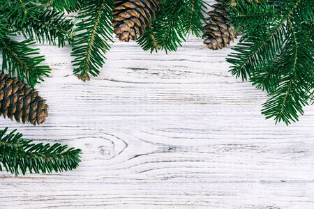 Christmas wooden background with fir tree and pine cone. Top view, copy space. Toned.の写真素材