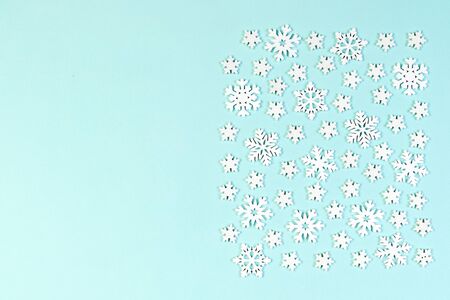 Top view of white snowflakes on colorful background. Winter weather concept with copy space. Merry...