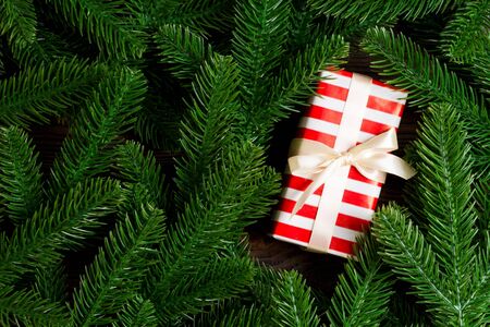Top view of festive gift box decorated with green fir tree branches. Christmas time with copy space.の写真素材