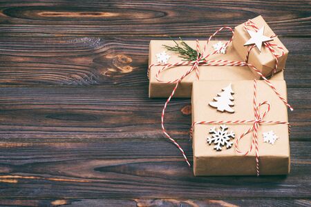 Christmas gift box with copy space. Xmas present boxwith decoration on wooden background. Toned.